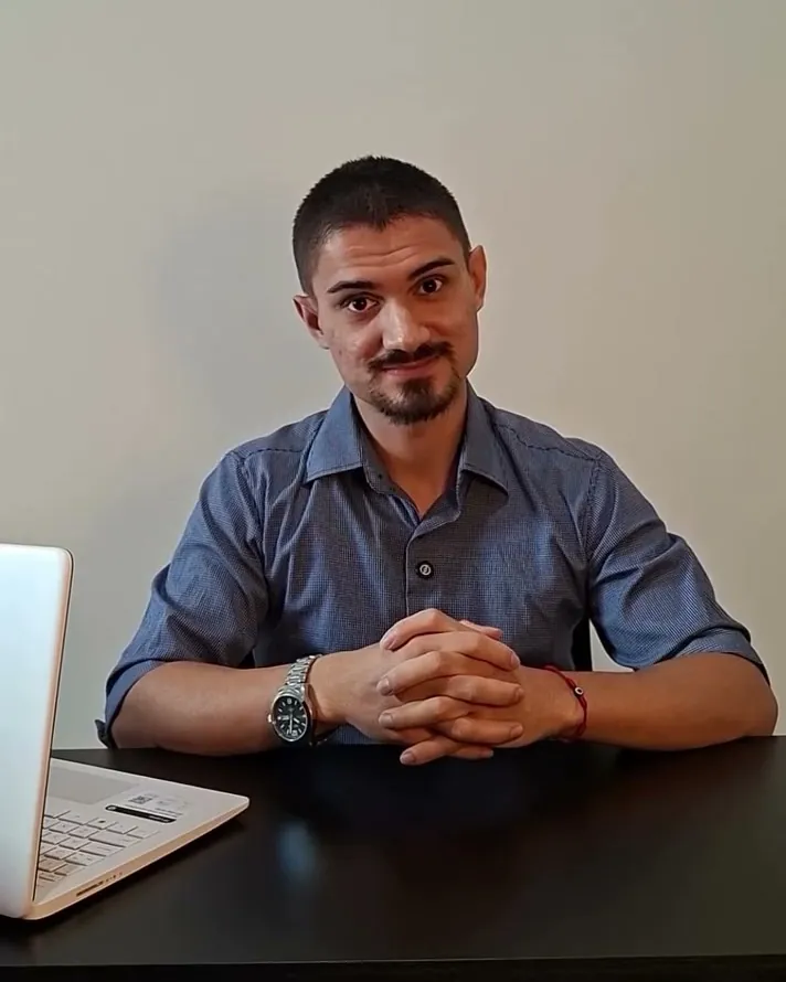 David Bento sentado à mesa do consultório